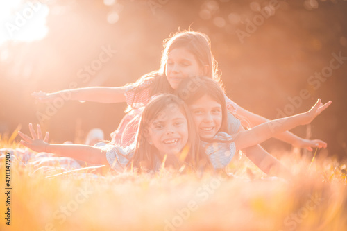Childhood moments. Three little girl lying on grass.