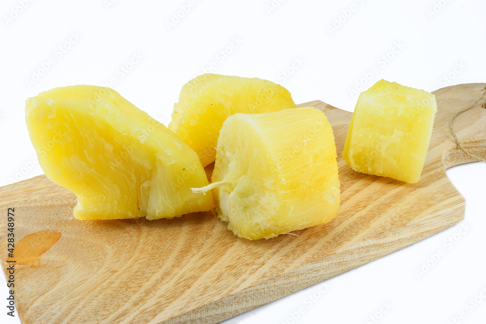steamed cassava on a wooden cutting board steamed cassava on a wooden cutting board