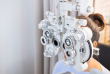 Selective focus at Optometry frame equipment. While doctor using penlight and subjective refraction to  examine eye visual system of elder patient women with professional machine before made glasses.