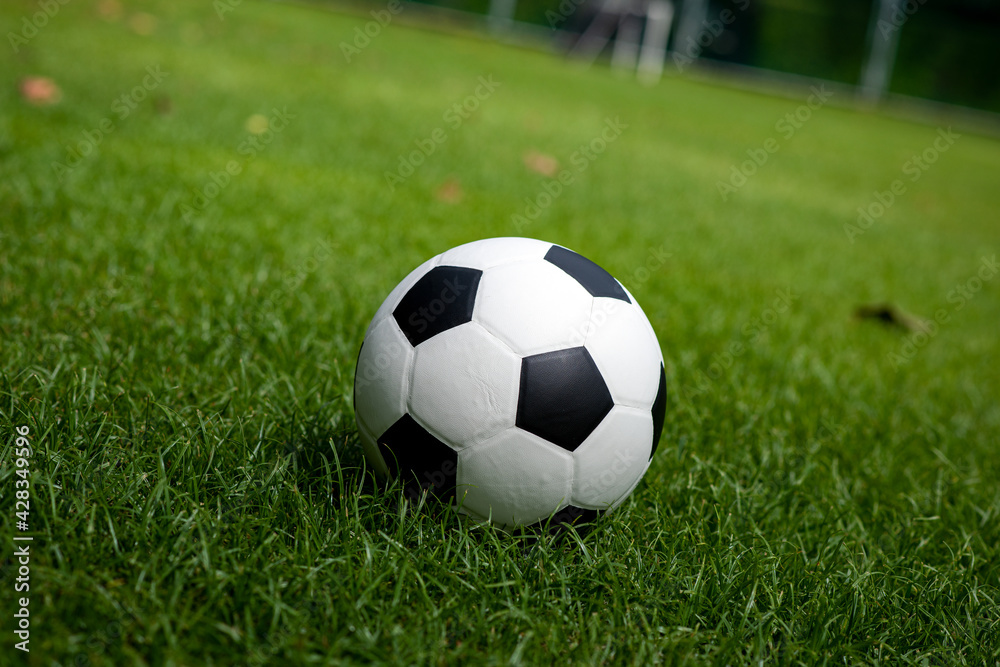Football placed on a grass pitch in the afternoon awaiting for teams practicing or matches in a tournament. Football placed on a grass pitch in the afternoon awaiting for teams practicing or matches in a tournament.