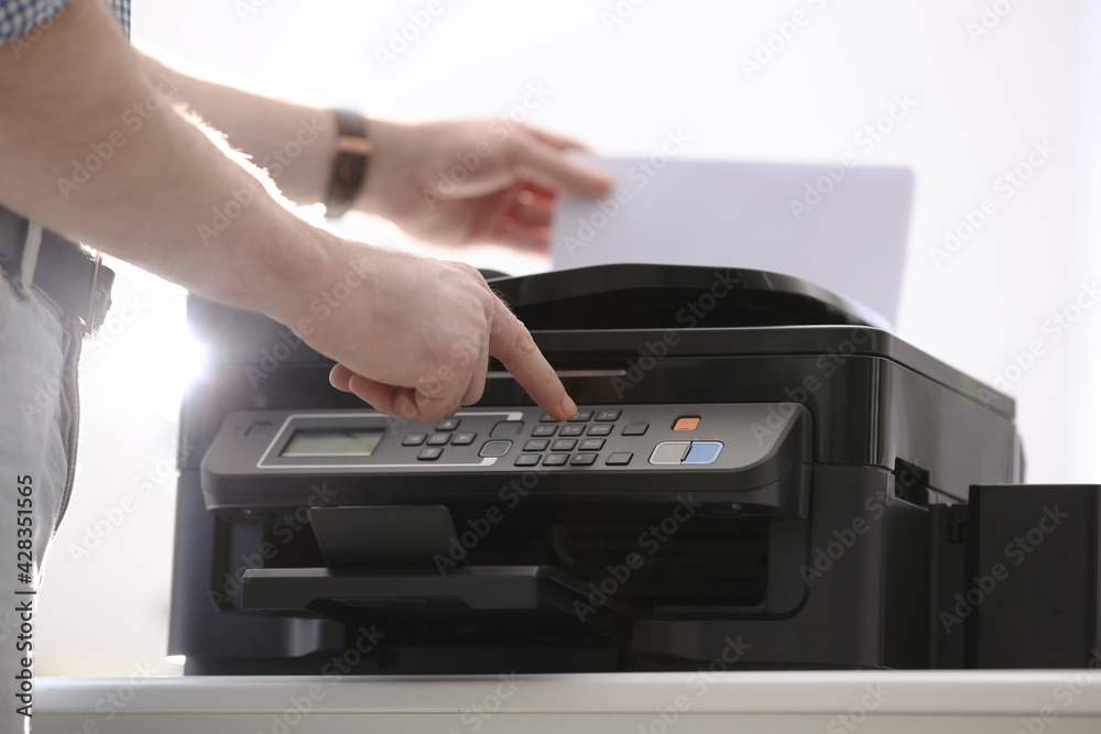 Employee using modern printer in office, closeup Employee using modern printer in office, closeup