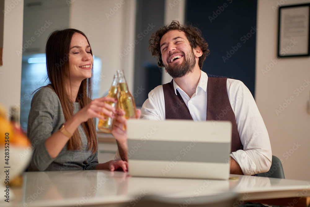 A young handsome business couple toasting at home after successful working day. Business, relationship, leisure A young handsome business couple toasting at home after successful working day. Business, relationship, leisure