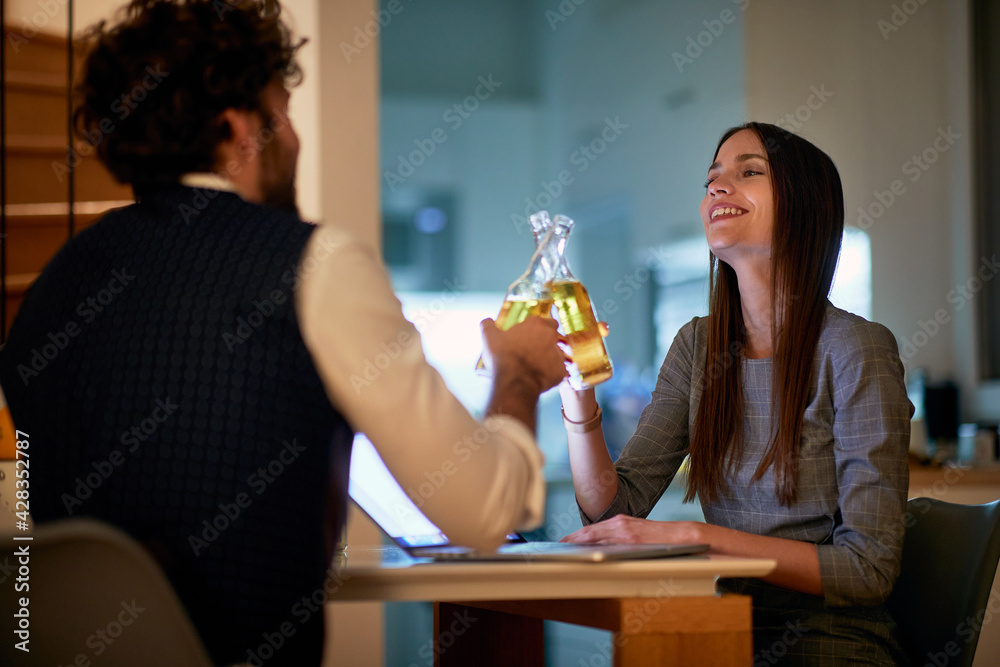 A young sexy businesswoman enjoying a drink with a handsome businessman at a date in an apartment. Business, date, relationship A young sexy businesswoman enjoying a drink with a handsome businessman at a date in an apartment. Business, date, relationship