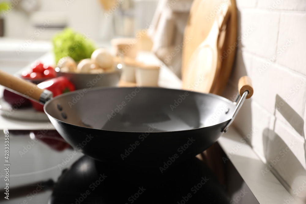Frying pan on modern cooktop in kitchen - obrazy, fototapety, plakaty 