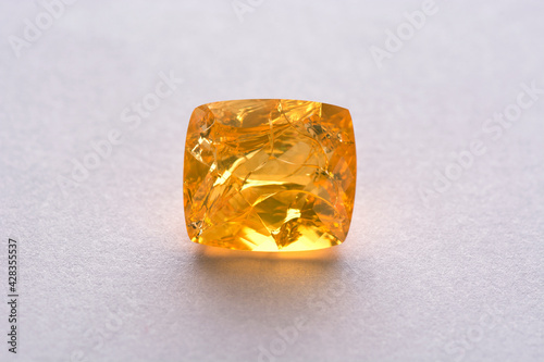 Natural Ethiopian hydrophane porous honey yellow color transparent fire opal: damaged, big through cracks in the crystal mass after been dried out. Opal physical properties. White background. Close-up