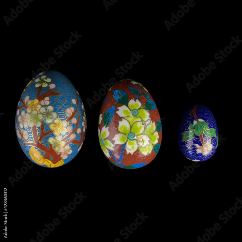 set of wooden Easter eggs with floral patterns on isolated black background