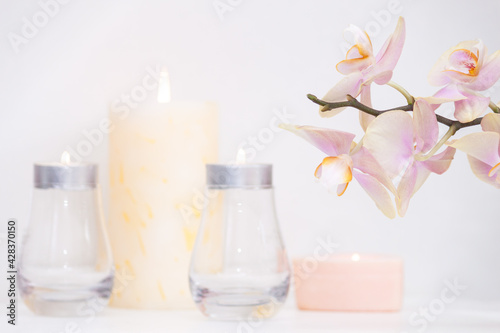 Burned candles and orchid flowers. Calm and relax concept.