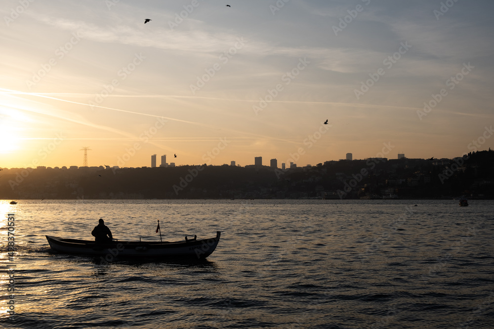 Istanbul / Turkey - January 30 2020: Man in rowboat at sunset
