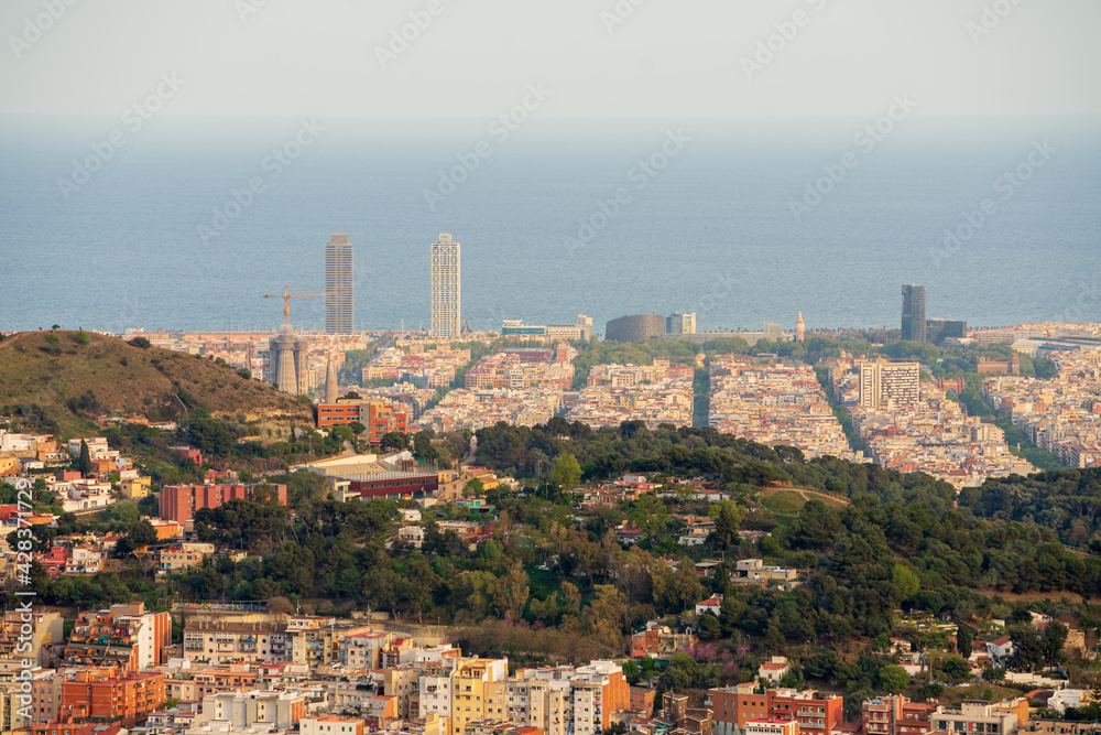 Panoramic view of the city of Barcelona from the viewpoint of L'Arrabassada. During sunset, a spring day. The sky is completely covered with clouds.