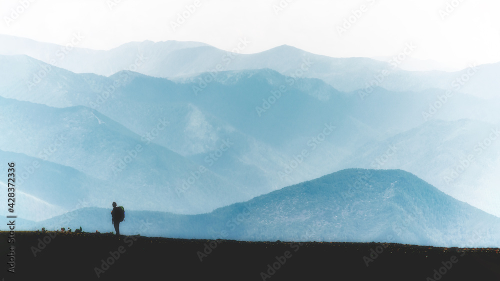 a person in the mountain cascade with backpack in blue colours a person in the mountain cascade with backpack in blue colours
