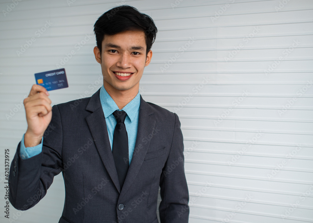 Cheerful Asian businessman advertising credit card