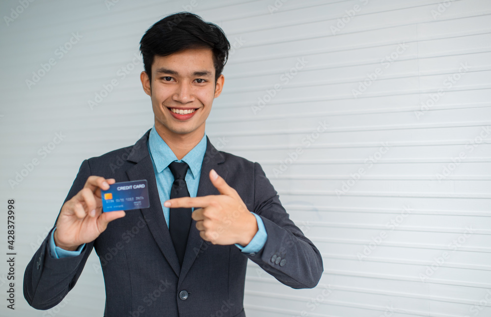 Asian male manager demonstrating credit card Asian male manager demonstrating credit card