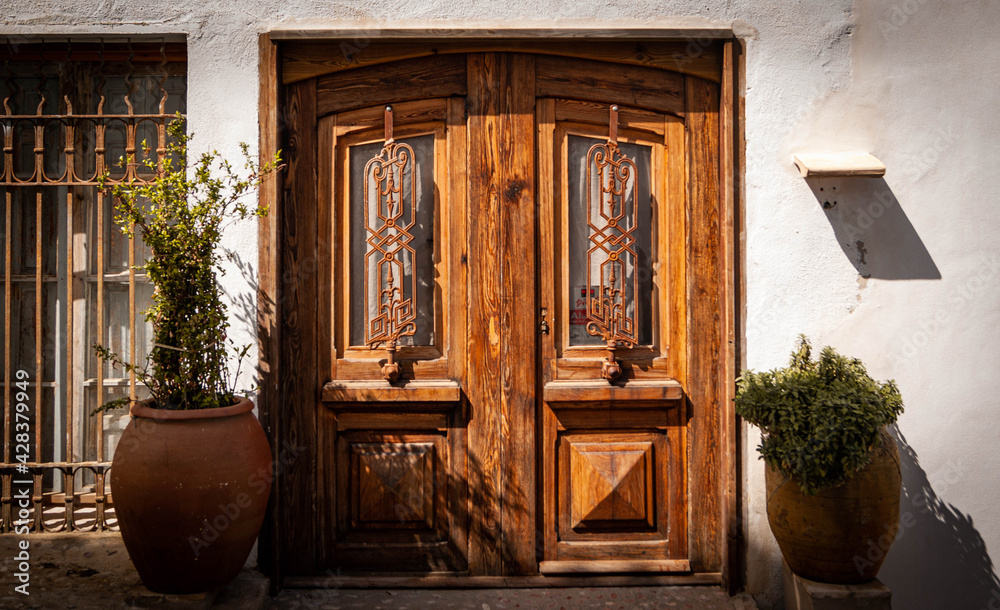 Puerta de madera en casa blanca de estilo mediterráneo en Altea, Alicante. Puerta y fachada vintage.  - obrazy, fototapety, plakaty 