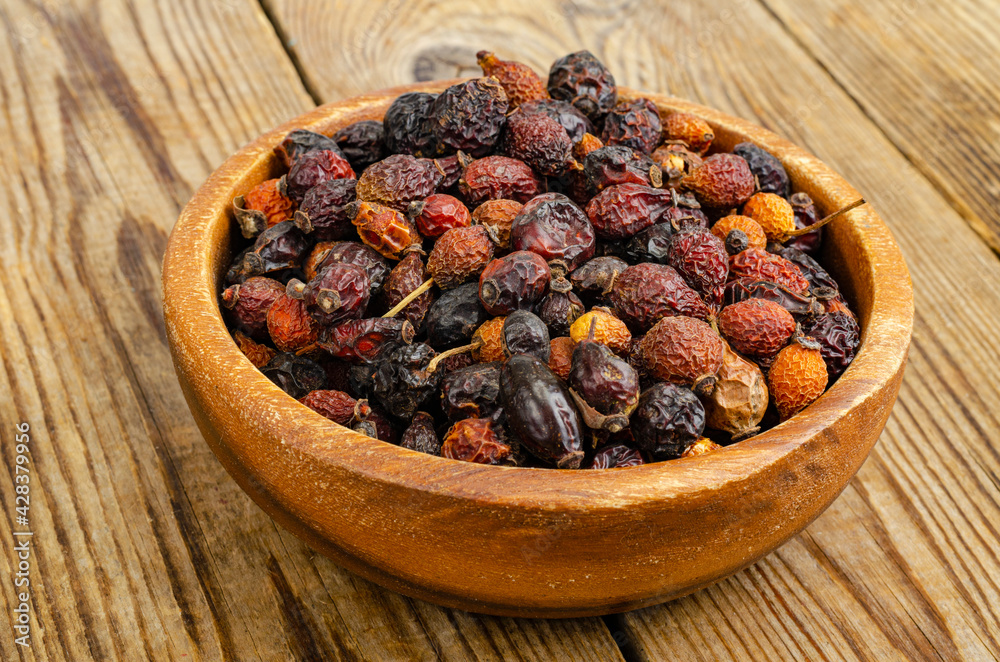 Dried rose hips in wooden bowl, natural vitamin C. Dried rose hips in wooden bowl, natural vitamin C.