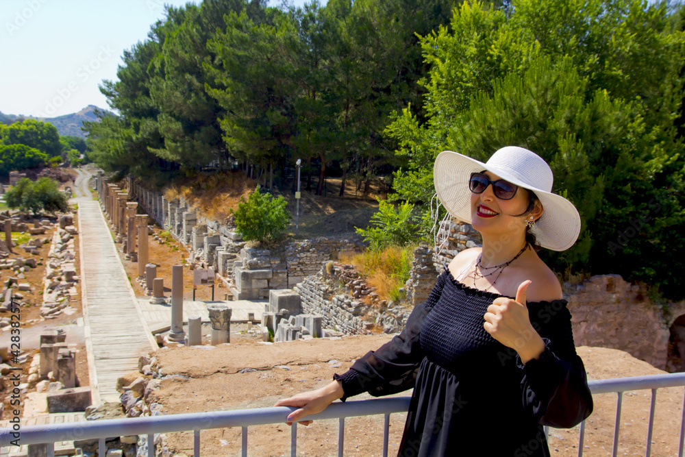 Beautiful young woman in black dress in Ephesus ancient city	