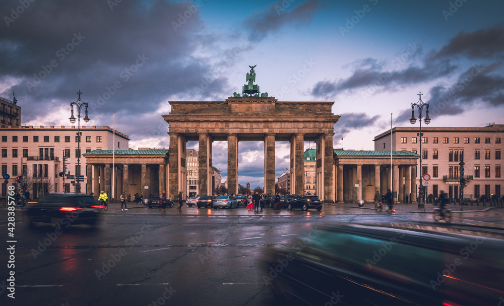 Fototapeta premium Famous Brandenburger Tor, Brandenburg Gate, one of the best-known landmarks and national symbols of Germany, artificially lit in front of cloudy sky in Berlin, Germany