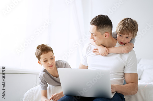 Work from home. Father working with children and laptop computer at home. Quarantine and closed school during coronavirus outbreak. 