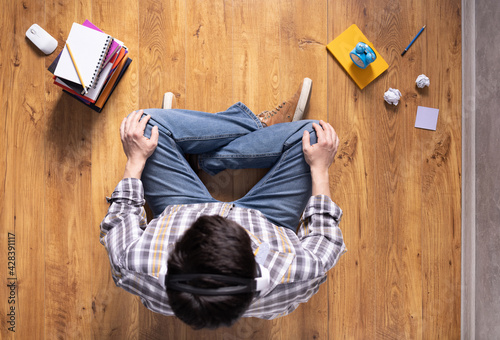 Man relaxing on floor thinking idea solitions. Man student studying online lesson siiting on floor