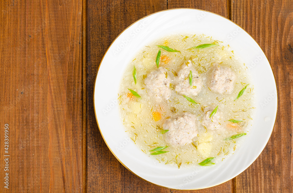 White plate of meatball soup. Studio Photo