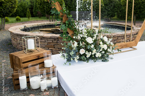 Close up of wedding ceremony with arch in rustic style with fresh flowers