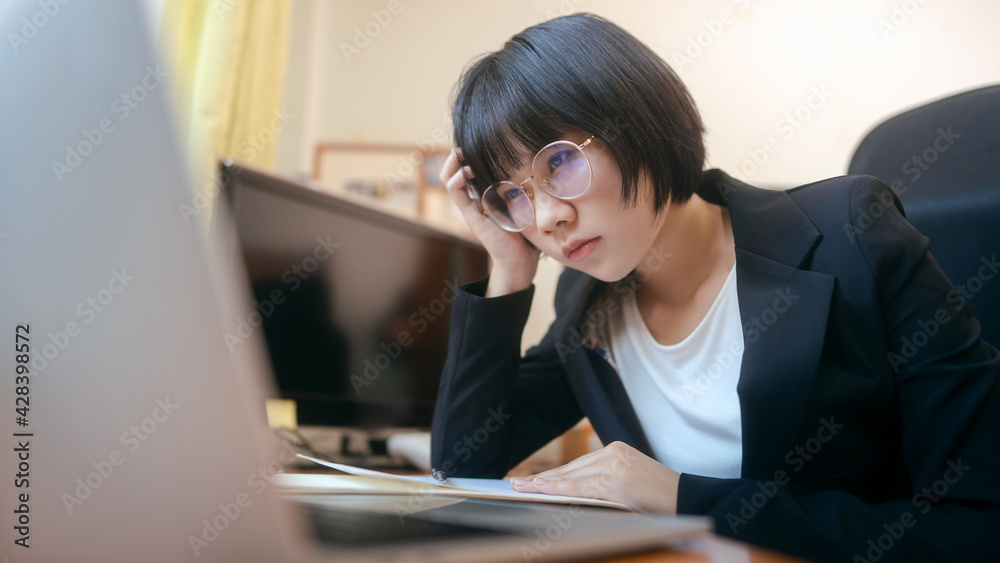 Young adult asian business woman wear eyeglasses work from home has stress and headache on day. Young adult asian business woman wear eyeglasses work from home has stress and headache on day.