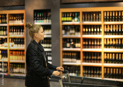 Woman choosing a dairy products at supermarket.woman choosing a wine, champagne at supermarket