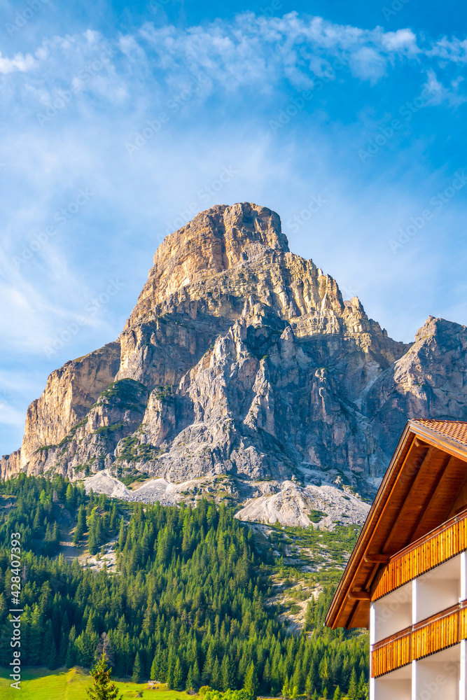 Magical Dolomite peaks, forests and hotels at sunny day and blue sky, Colfosco, Corvara, at Puez-Geisler, Puez-Odle Nature Park, South Tyrol, Italy.
