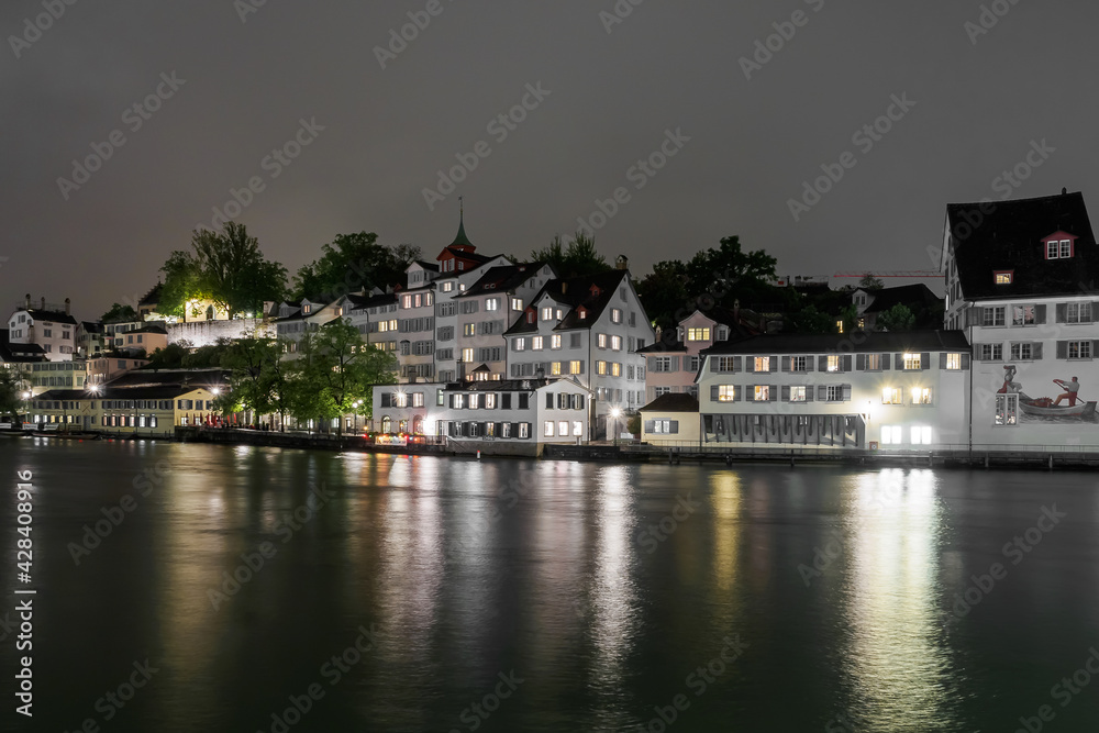 River Limmat and light in the windows of houses at night in Zurich River Limmat and light in the windows of houses at night in Zurich