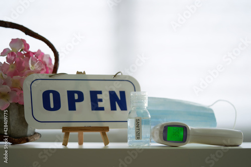 open sign with face mask hand sanitizer and thermometer, sop during the pandemic.