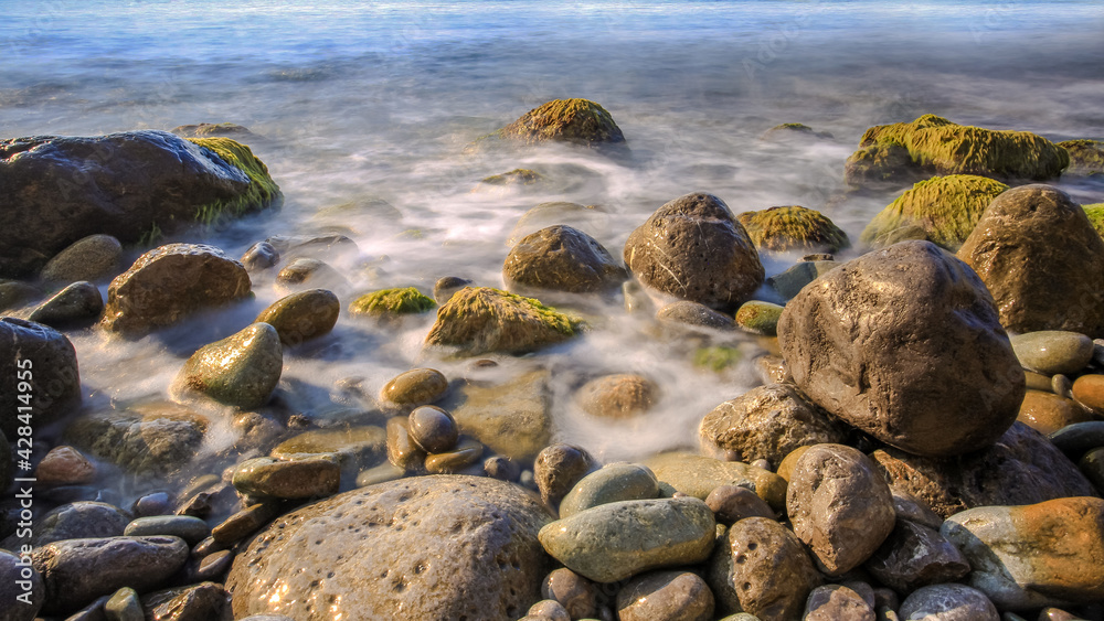 Sea surf. Stones on the beach. Sea foam. The southern coast of Crimea.