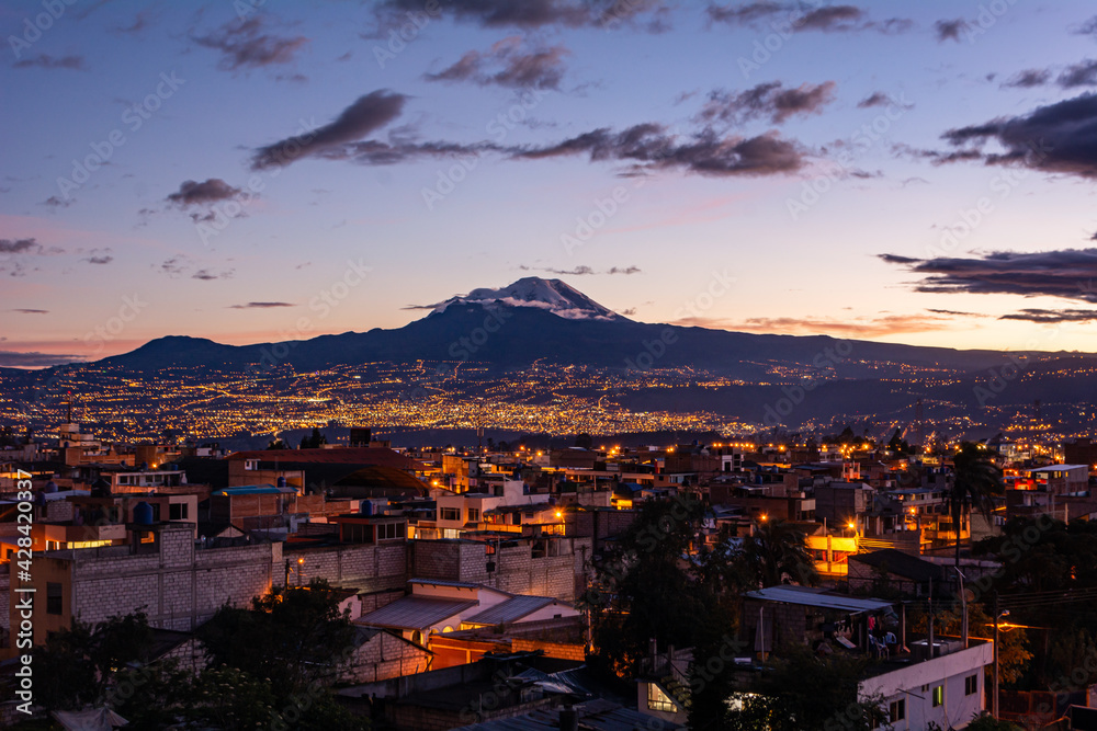 Chimborazo Volcano next to a beautiful city at a beatiful sunset