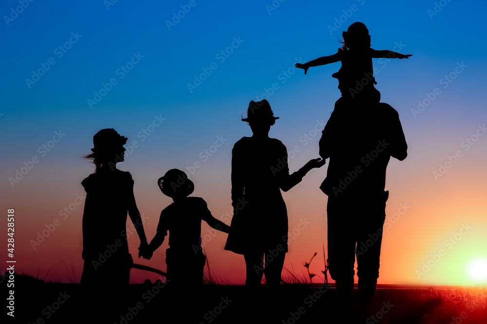 Obraz premium A Happy family by the sea at sunset in travel silhouette in nature