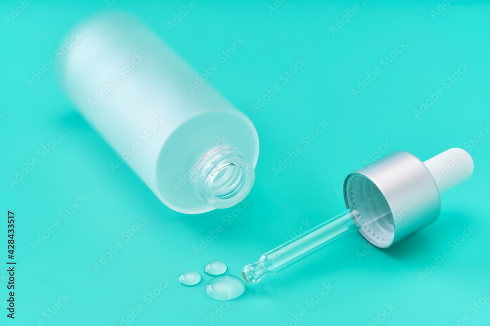 a drop of hydrating facial serum on a blue background. a drop of hydrating facial serum on a blue background.