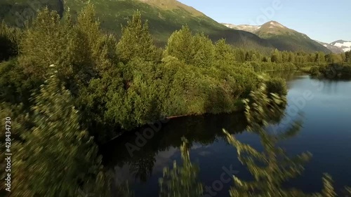 push in through trees of a small lake at the base of a large mountain