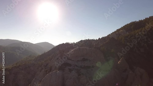 rotating shot of a large cliff face along the side of a heavily wooded mountain range