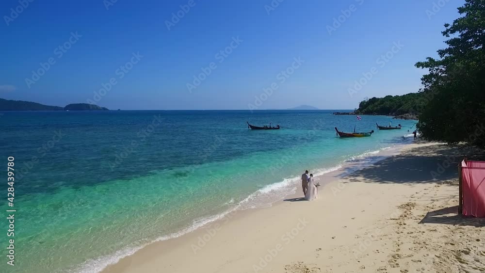 Wedding Couple Walking on the beach arch pink colors. Aerial view.Samui,Krabi,Phuket, Thailand. view of the sea from the beach ,Long boat Wedding Couple Walking on the beach arch pink colors. Aerial view.Samui,Krabi,Phuket, Thailand. view of the sea from the beach ,Long boat