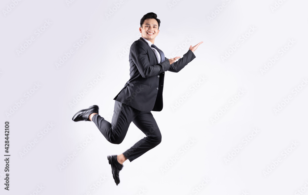 Young Asian businessman jumping on white background
