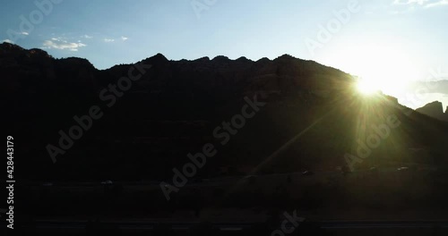 Sunrise peaking out from behind landform