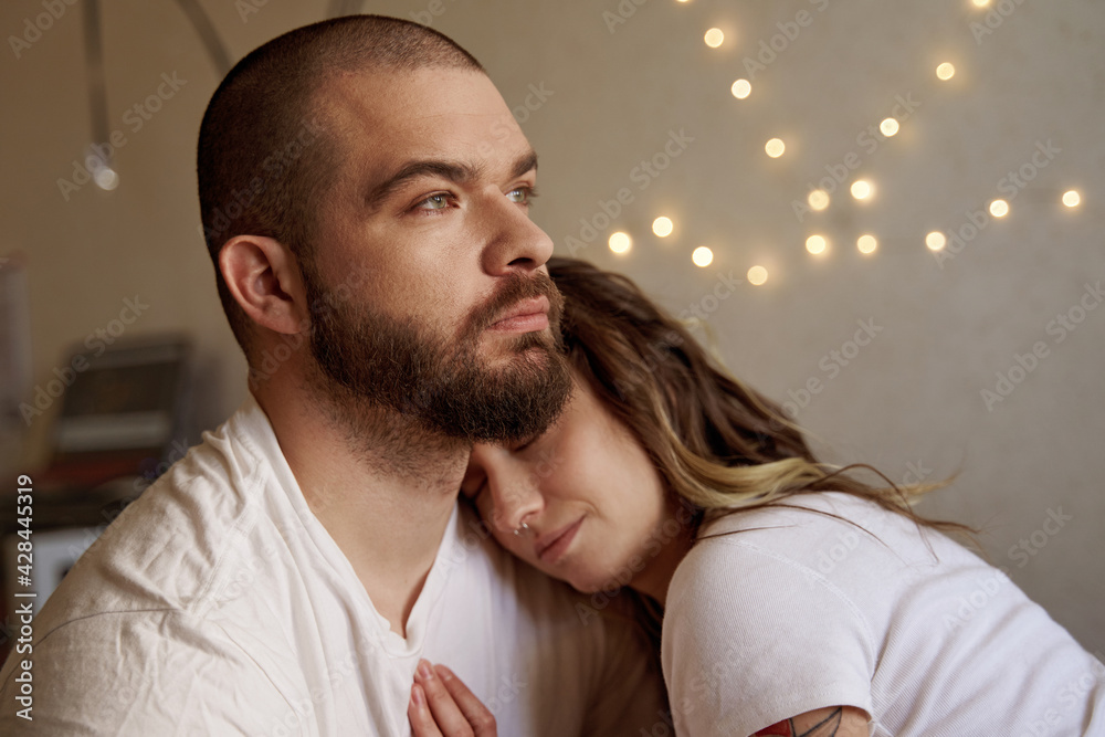 Fototapeta premium Couple in love embracing and cuddling at the bedroom
