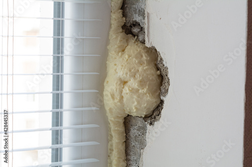 Installation of windows. Polyurethane foam on the slope of the window. Sealing window slopes.