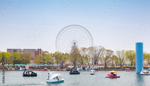 Pedal boats in Yume-no-ike (Dream Pond) and Expo '70 Pavilion in Expo '70 Commemorative Park, and Redhorse Osaka Wheel in Expocity in Osaka, Japan photo