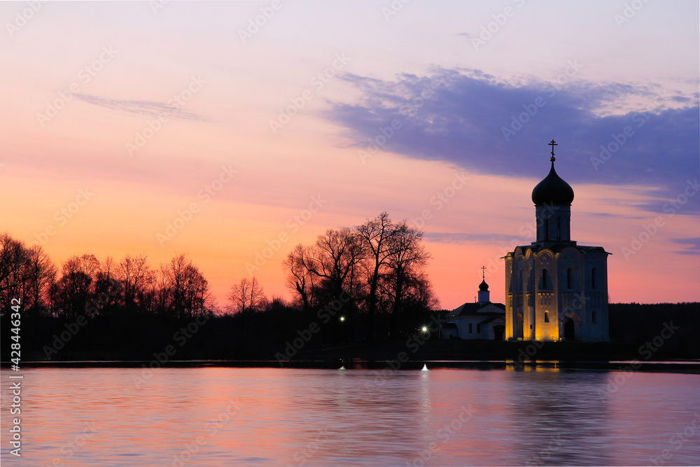 Multicolored April sunrise overlooking the Church of the Intercession on the Nerl and the abundantly flooded meadow.