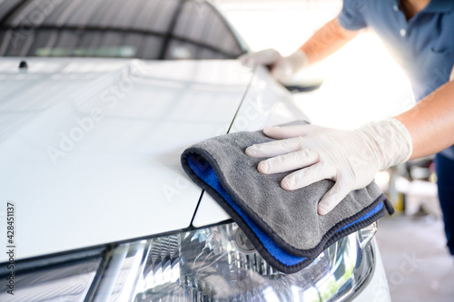 Car wash service personnel clean their cars with microfiber cloths. Details and valet concept Selective focus Close-up view photo