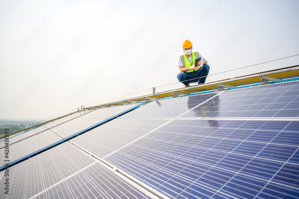 Young electrical engineer Work in a photovoltaic power plant Checking solar panel quality And control the electricity in the building by a photovoltaic system technician