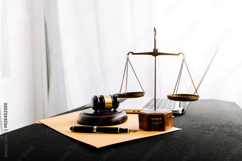 Business and lawyers discussing contract papers with brass scale on desk in office. Law, legal services, advice, justice and law concept picture with film grain effect
