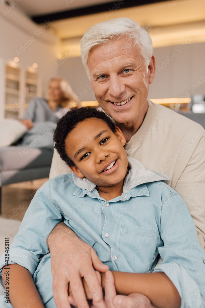 Father embracing his multiracial son with tenderness and posing Father embracing his multiracial son with tenderness and posing