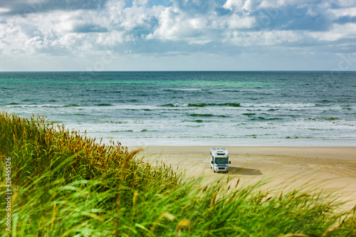 Wohnmobil auf einem Sandstrand am Meer
