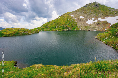 summer scenery with lake on high altitude. beautiful landscape of fagaras mountain ridge in summer. open view in to the distant peak beneath a fluffy clouds