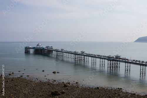 Llandudno pier in summer. North Wales tourist destination. Old victorian pier at low tide
