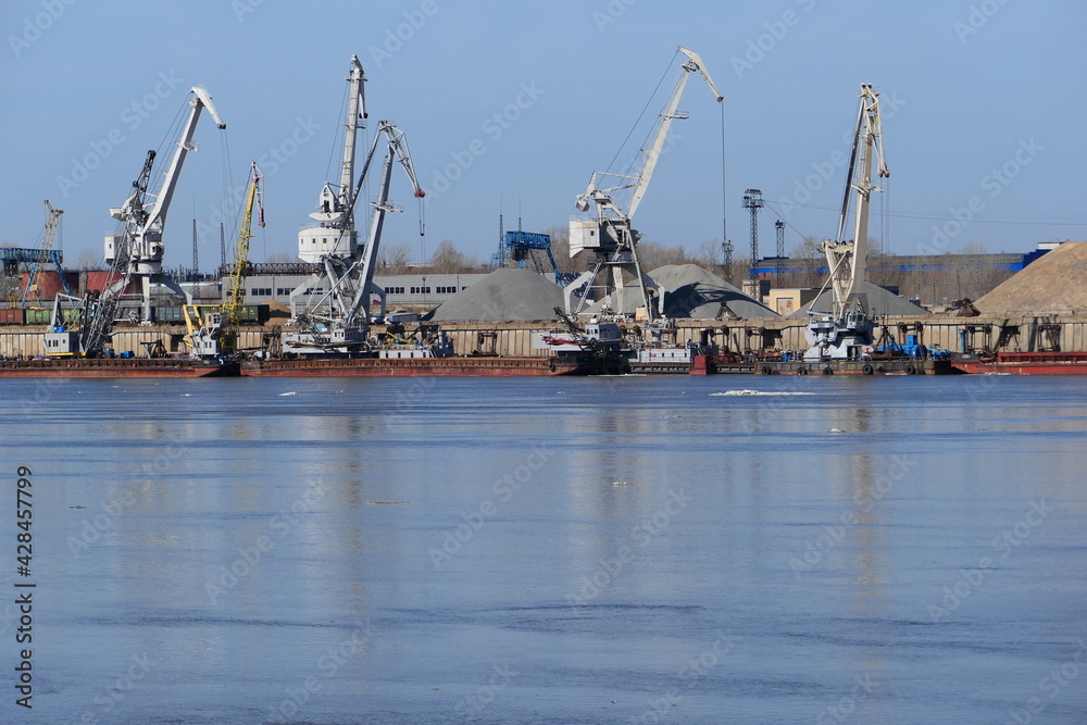 View of a large river and river port with special equipment and water transport. High quality photo View of a large river and river port with special equipment and water transport. High quality photo
